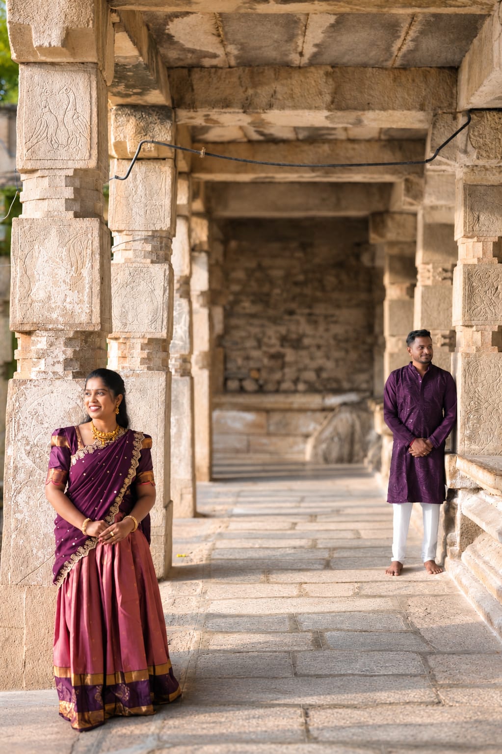 Sanju and Sonu seated together outside an ancient temple